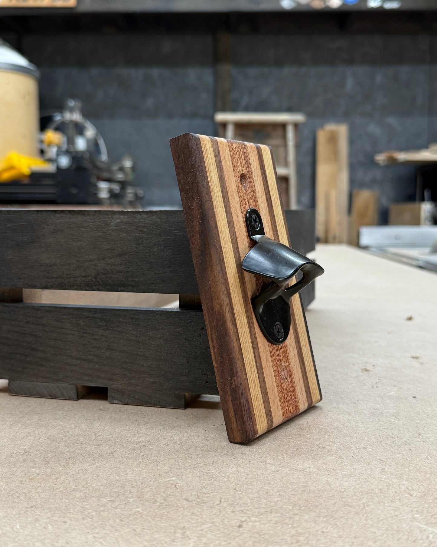 Wooden bottle opener on a concrete surface with a blurred background