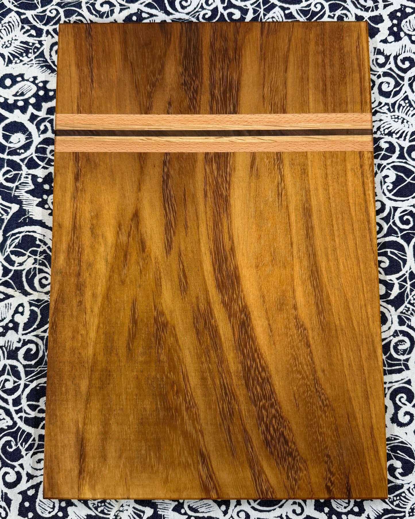 Wooden cutting board on a patterned fabric background