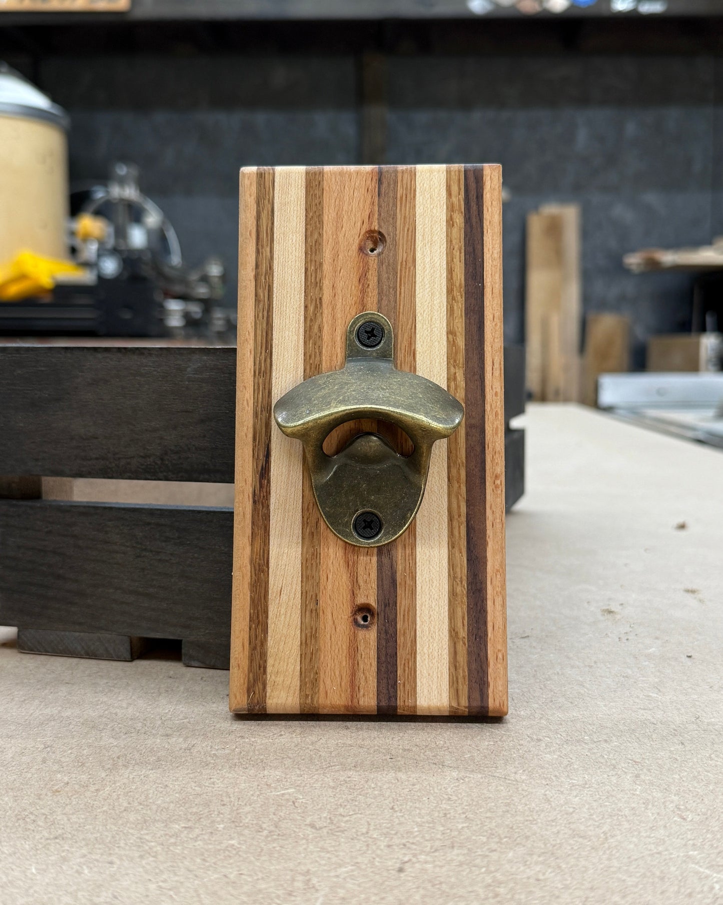Wooden bottle opener with metal cap catcher on a counter