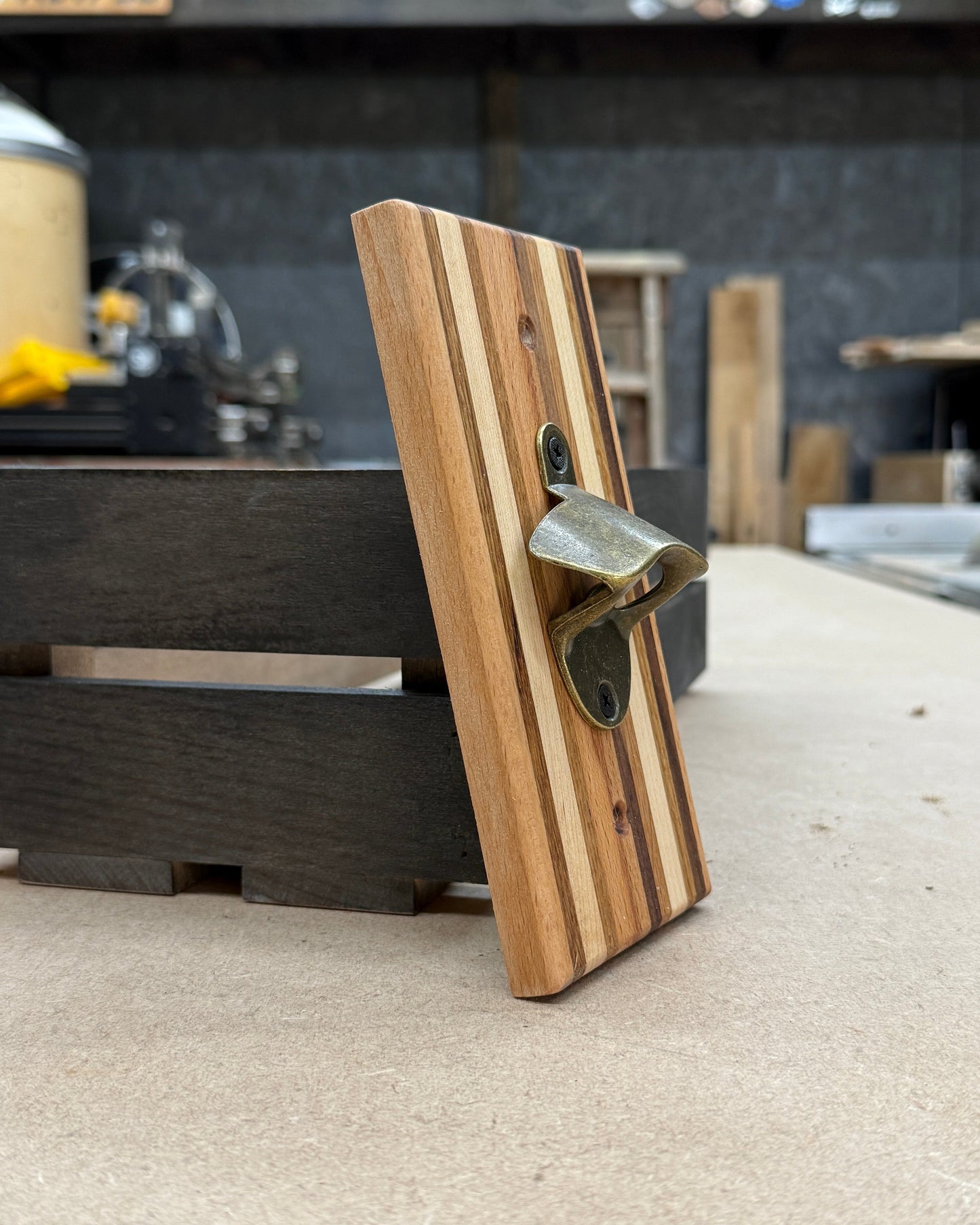 Wooden bottle opener on a concrete surface with a blurred background