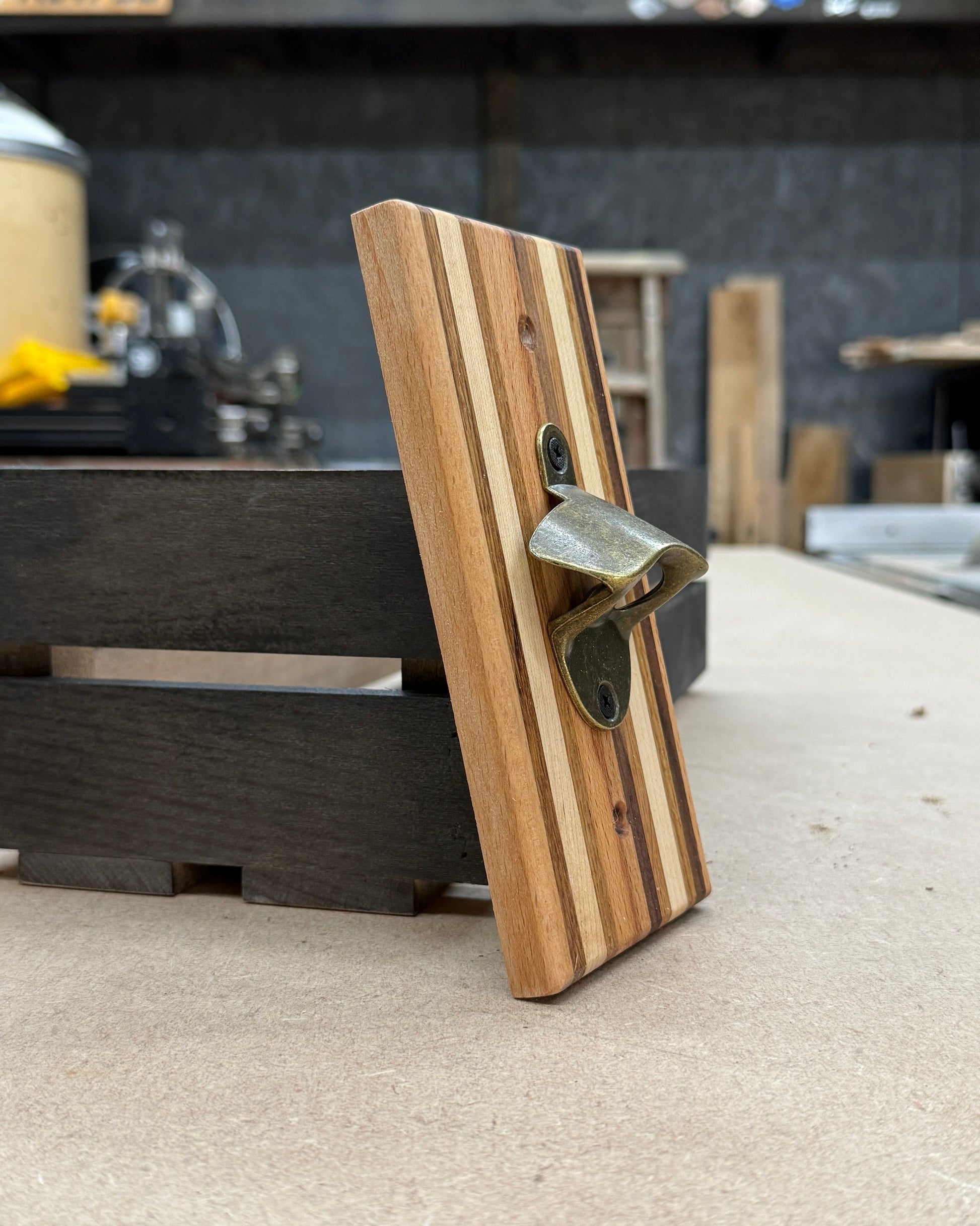 Wooden bottle opener on a concrete surface with a blurred background