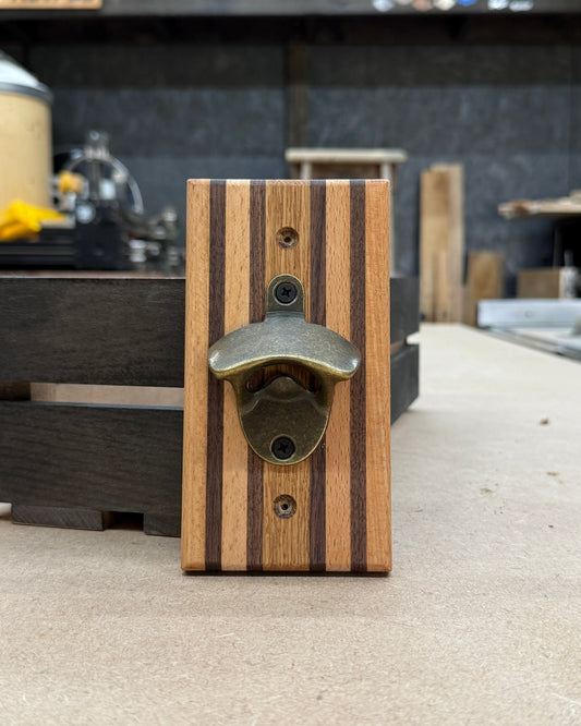 Wooden bottle opener with metal cap catcher on a concrete floor.
