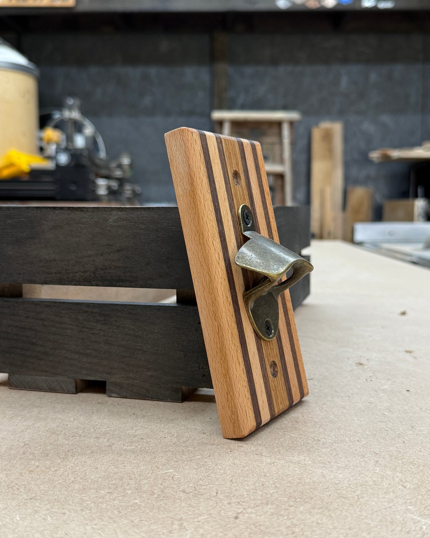 Wooden bottle opener on a concrete counter with a blurred background