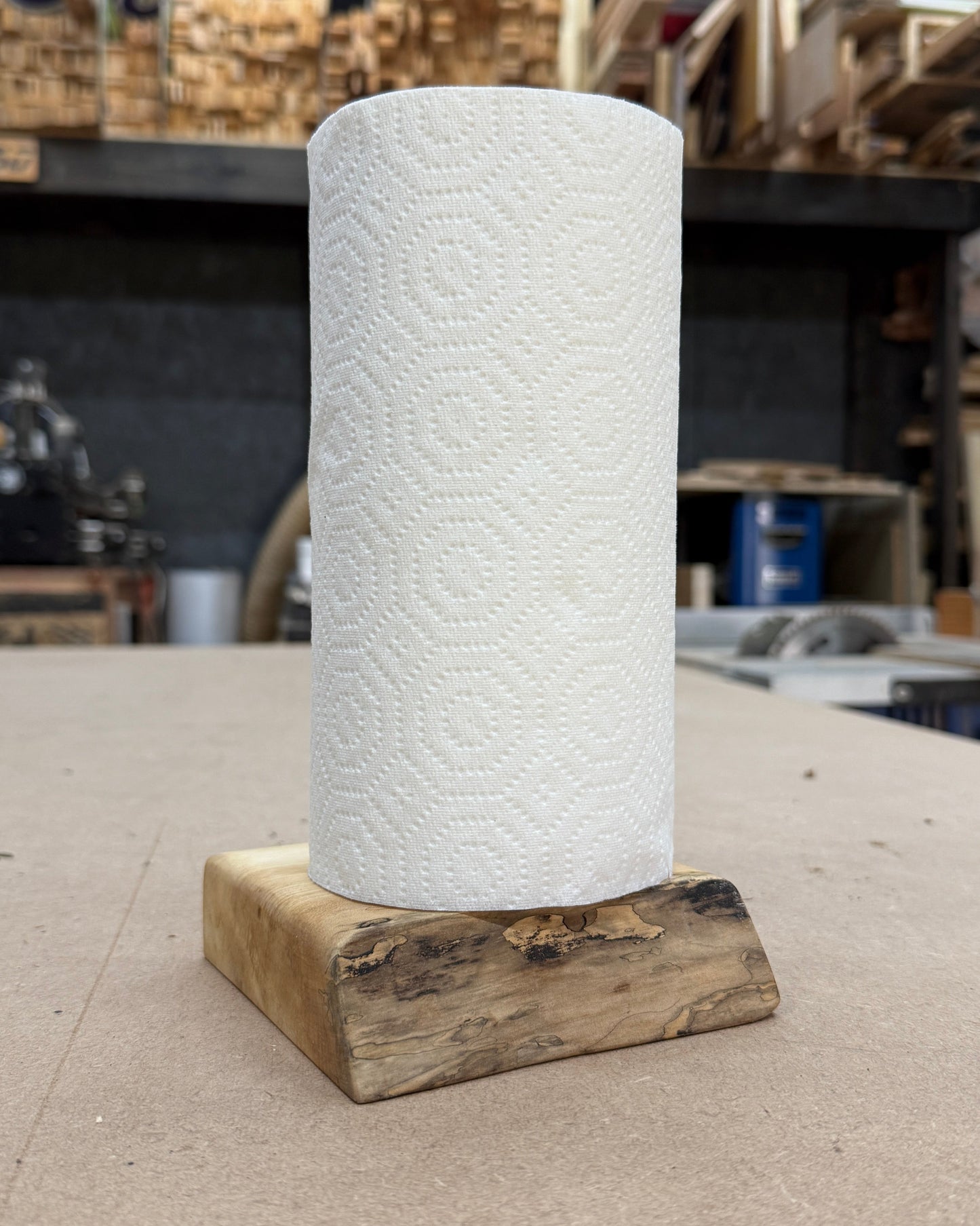 Roll of paper towels on a wooden stand in a workshop setting
