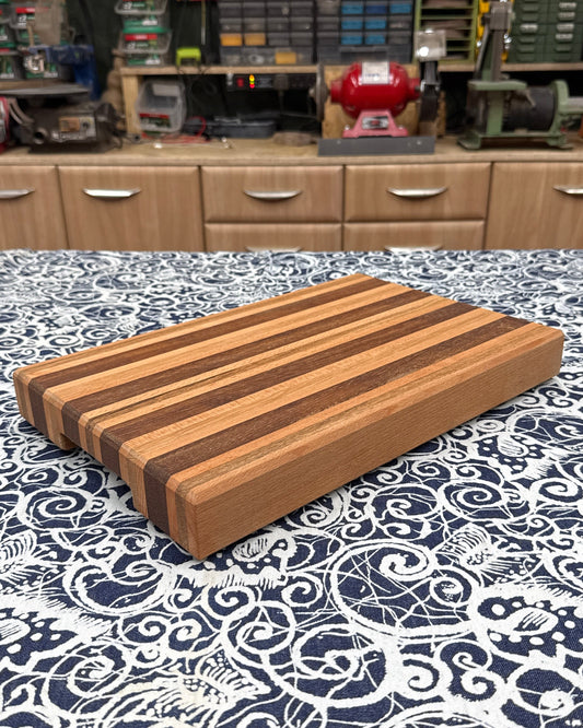 Wooden cutting board on a patterned tablecloth with workshop background