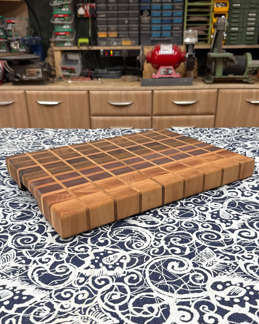 Brown cutting board on a patterned tablecloth with a workshop in the background