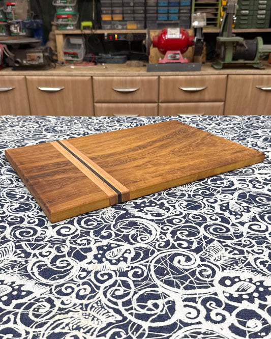 Wooden cutting board on a patterned tablecloth with a workshop in the background