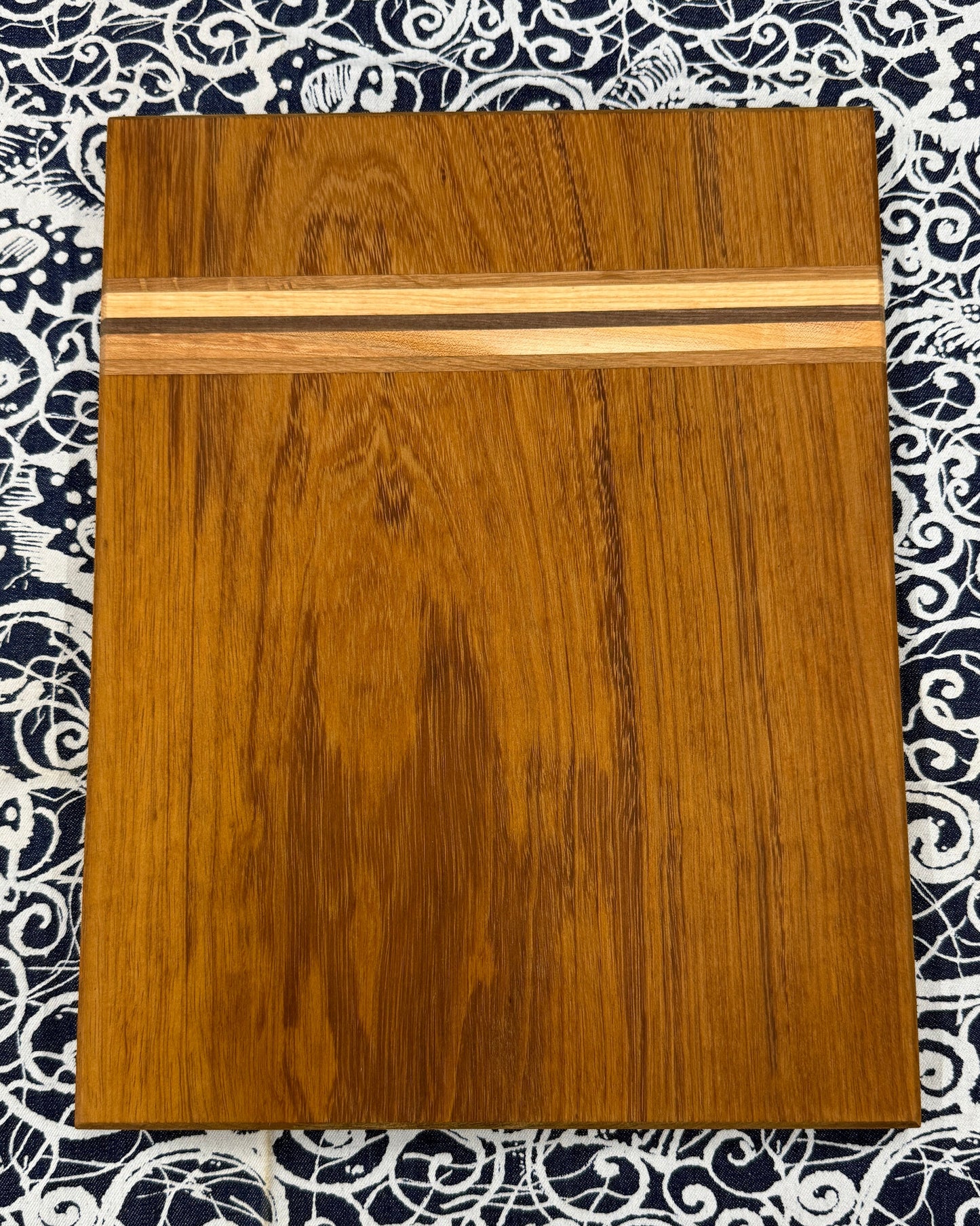 Wooden cutting board on a patterned fabric background